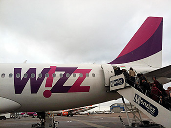 Sacred Harp singers board a bright pink Wizz Air plane. Photograph by Lauren Bock. Sacred Harp singers board a bright pink Wizz Air plane. Photograph by Lauren Bock.